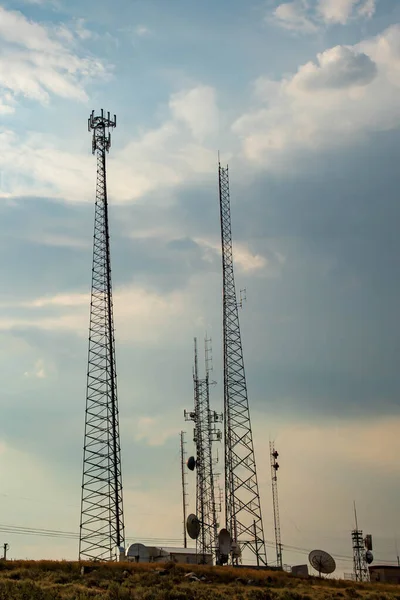 Looking up at Communications towers with blue skies and white clouds
