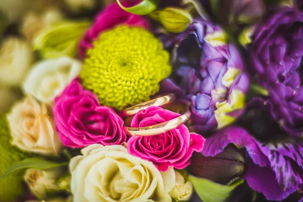 Wedding rings and roses bouquet — Stock Photo, Image