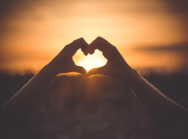 Forme d'amour silhouette de main dans le ciel Photo De Stock