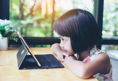 Evde dizüstü bilgisayar kullanan mutlu çocuklar.