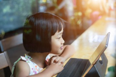 Evde dizüstü bilgisayar kullanan mutlu çocuklar.