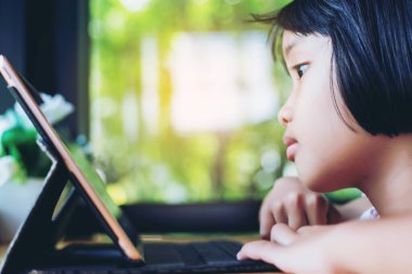 Evde dizüstü bilgisayar kullanan mutlu çocuklar.