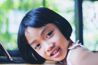 Evde dizüstü bilgisayar kullanan mutlu çocuklar.