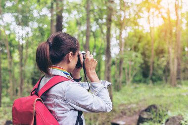 Fotoğraf çekimi. Genç ve güzel bayan fotoğrafçı, antika retro kamerayla fotoğraf çekiyor..