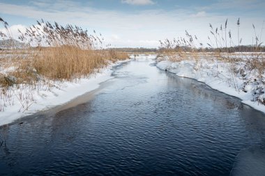 Nehir kış mevsiminde dinlenir ve doğada karlı bir manzara vardır. Köy 'de 