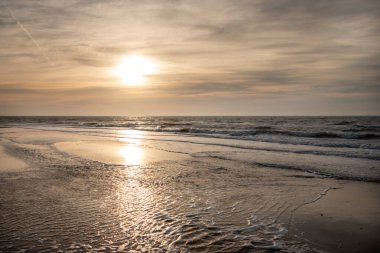 Kuzey Denizi kıyısında güneşli bir kış günbatımında Wadden Adası, Teksas, Hollanda