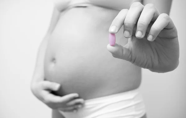 Витаминные таблетки в руках беременной женщины — стоковое фото