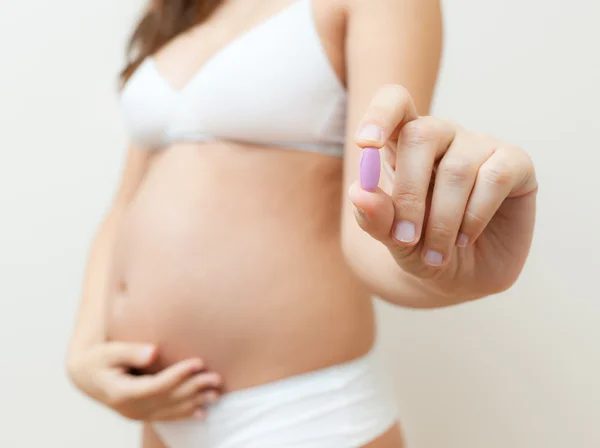 Vitamin pill in the hands of a pregnant woman — Stock Photo, Image