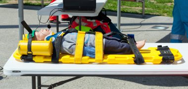 Taşıma için bir sedye üzerinde immobilize kukla.