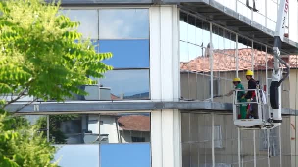 Nettoyant pour vitres travaillant sur une façade vitrée du bâtiment . — Video