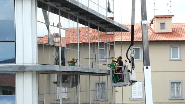 Nettoyant pour vitres travaillant sur une façade vitrée du bâtiment . — Video