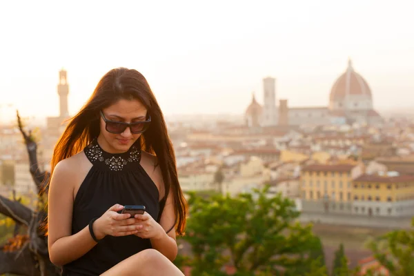 Teen at sunset in Florence uses the smartphone — Stock Photo, Image