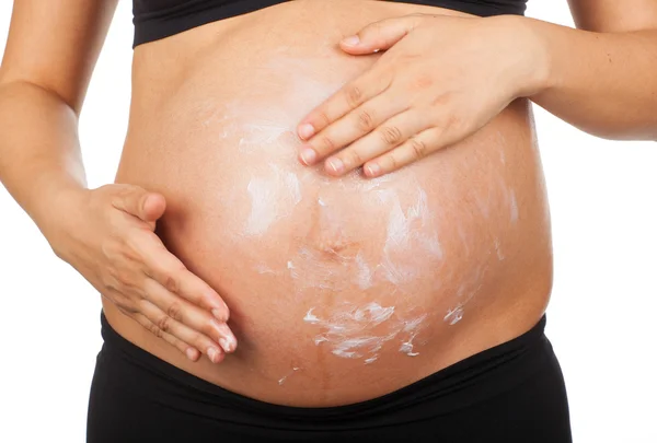 Zwangere vrouw masseren van haar buik met zalf tegen rek — Stockfoto