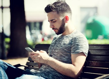 Genç adam akıllı telefon kullanıyor.