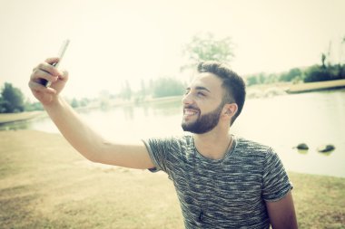 Genç adam akıllı telefon kullanıyor.