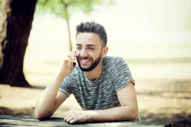 Genç adam akıllı telefon kullanıyor.