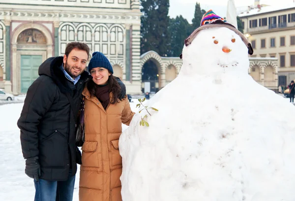 Casal em férias de inverno em Florença com boneco de neve — Fotografia de Stock