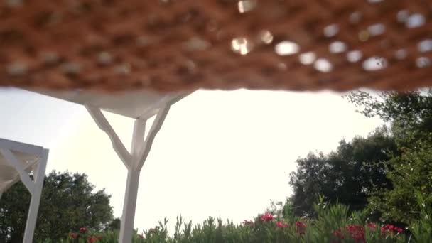 Стрілянина з солом'яним капелюхом в момент літньої релаксації біля басейну. Сцена з сонцем, і фламінго . — стокове відео