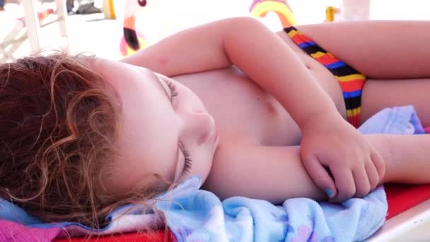 玩了一天之后 三岁的女孩睡在海滩上 — 图库视频影像