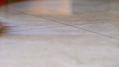 Cilalanmış mermer efekt zemini temizlerken mikrofiber bez ile paspasın yakın plan görüntüsü.