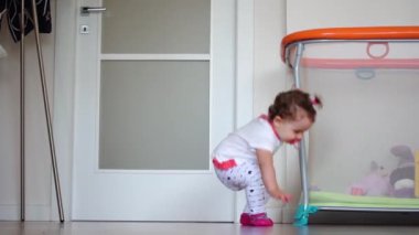 Bir yaşında bir kız evin içinde sürünüyor. Emeklemek, psikomotor gelişimine hazırlık egzersizidir..