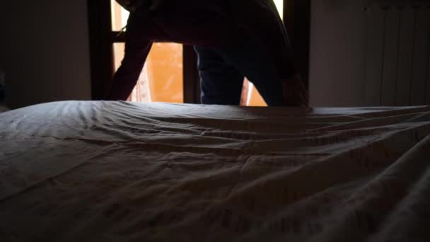 Der Erwachsene Mann Räumt Das Bett Mit Einem Baumwolltuch Auf — Stockvideo