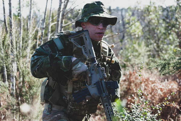 武装アサルトライフルとカモフラージュ制服でAirsoft軍事ゲームプレーヤー — ストック写真
