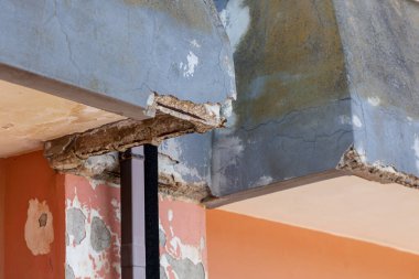 Çatlak beton ve paslı demirlerle kaplı duvar tadilat gerektiriyor..