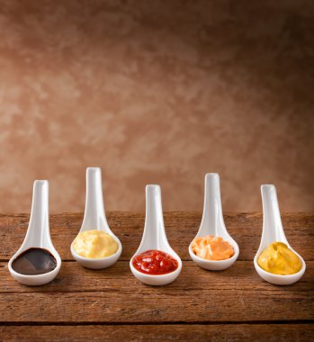 Sauces mixed in the ceramic spoons clipart
