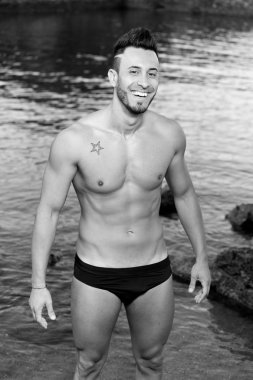 yakışıklı kaslı adam sahilde.