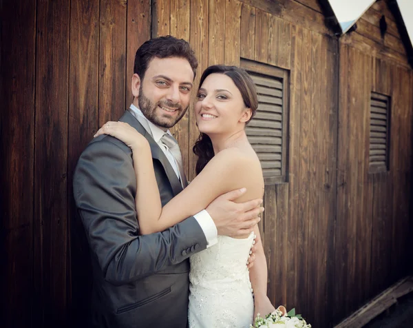 Casamento casal perto de cabines de madeira — Fotografia de Stock