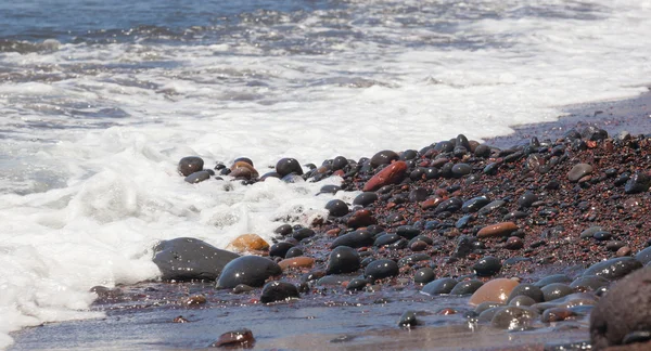 Red pebbles of the typical red beach of Santorini — Stock Photo, Image