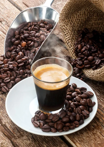 Café expreso en taza de vidrio con granos de café . —  Fotos de Stock