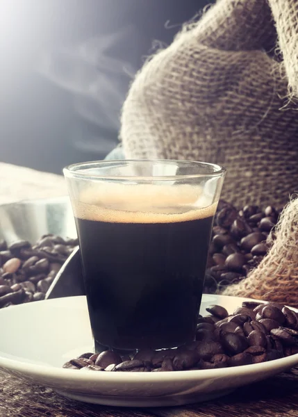 Café expreso en taza de vidrio con granos de café . —  Fotos de Stock