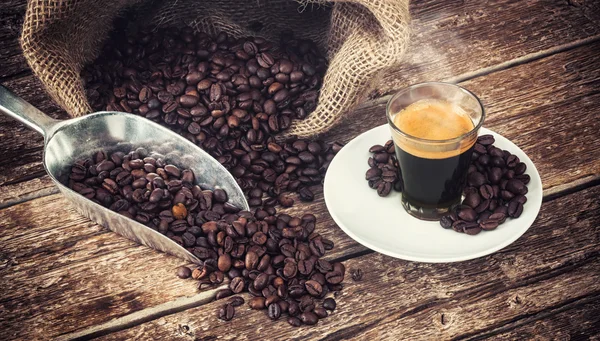 Espressokaffe i glas cup med kaffebönor. — Stockfoto