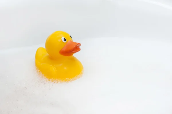 Rubber duck in foam bath — Stock Photo, Image