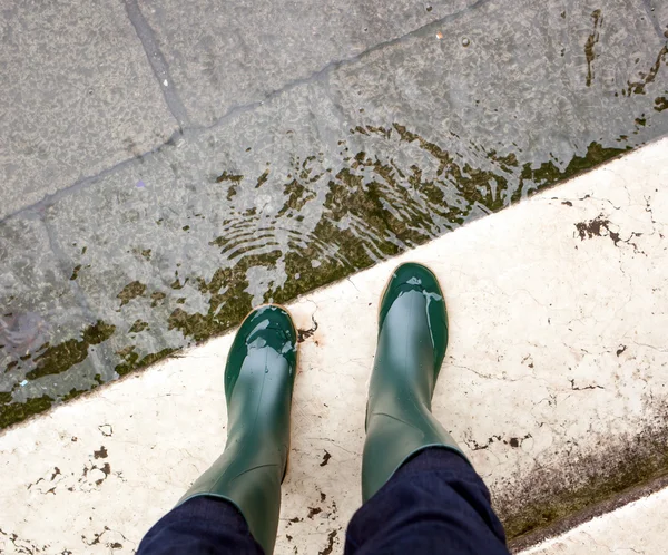 Primer plano de las piernas con botas debido a la alta agua en Venecia . — Foto de Stock