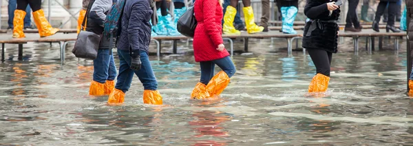 Primer plano de las piernas con botas debido a la alta agua en Venecia . —  Fotos de Stock