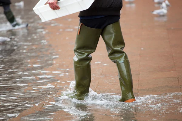 Gros plan des jambes avec des bottes en raison de la haute mer à Venise . — Photo