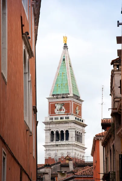 Nézd, a bell tower a San Mark házak között. — Stock Fotó