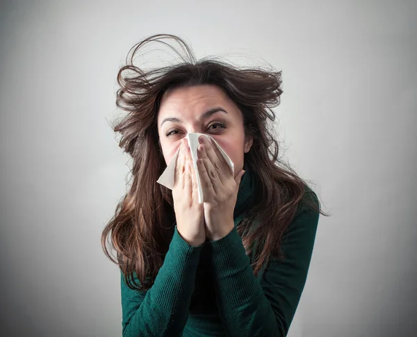 Giovane donna soffiando il naso con carta velina . — Foto Stock