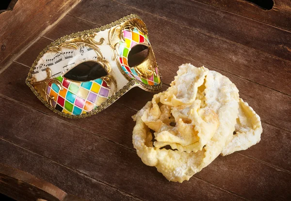 Pastelaria frita de carnaval italiano com máscara veneziana . — Fotografia de Stock