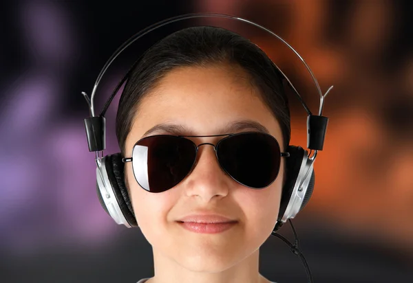 Mädchen mit Sonnenbrille beim Musikhören mit Kopfhörern. — Stockfoto