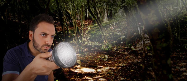 Uomo con una torcia nel bosco . — Foto Stock