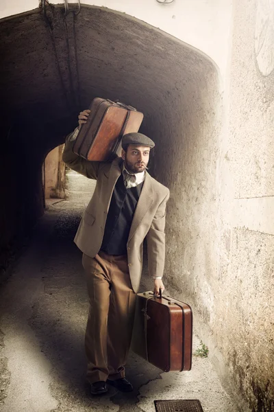 Emigrant man with the suitcases in a small town — Stock Photo, Image