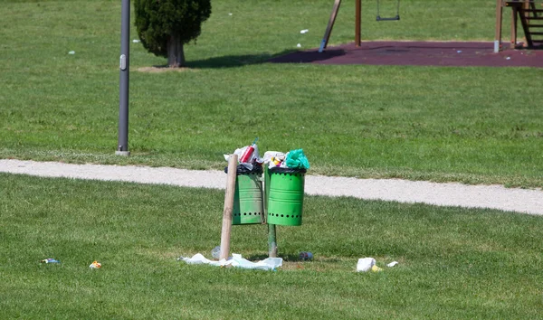 Cestino pieno in un parco all'aperto — Foto Stock