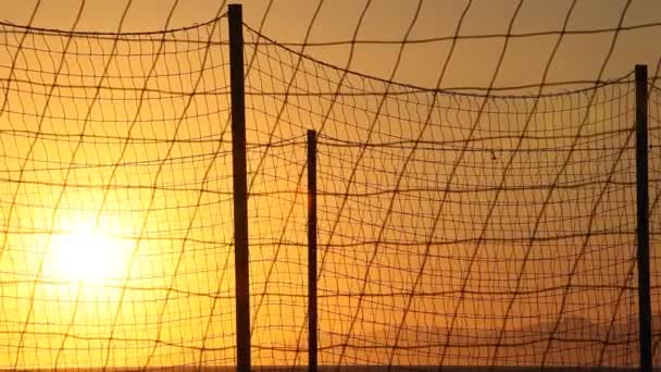 Sunset between netting fence — Stock Video