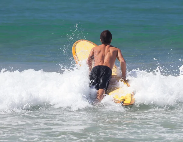 Surfer na longboard jeździ fala na morzu — Zdjęcie stockowe