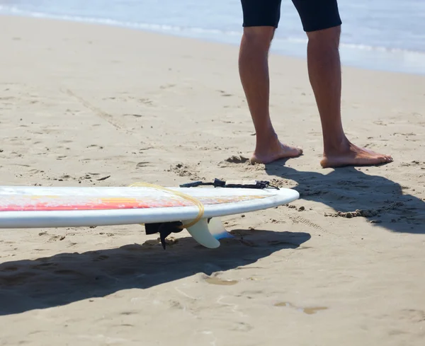 Серфер з дошкою на пляжі — стокове фото