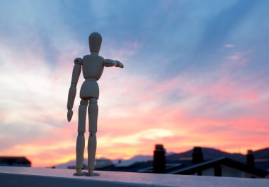 Wooden dummy pointing with his finger towards the horizon clipart